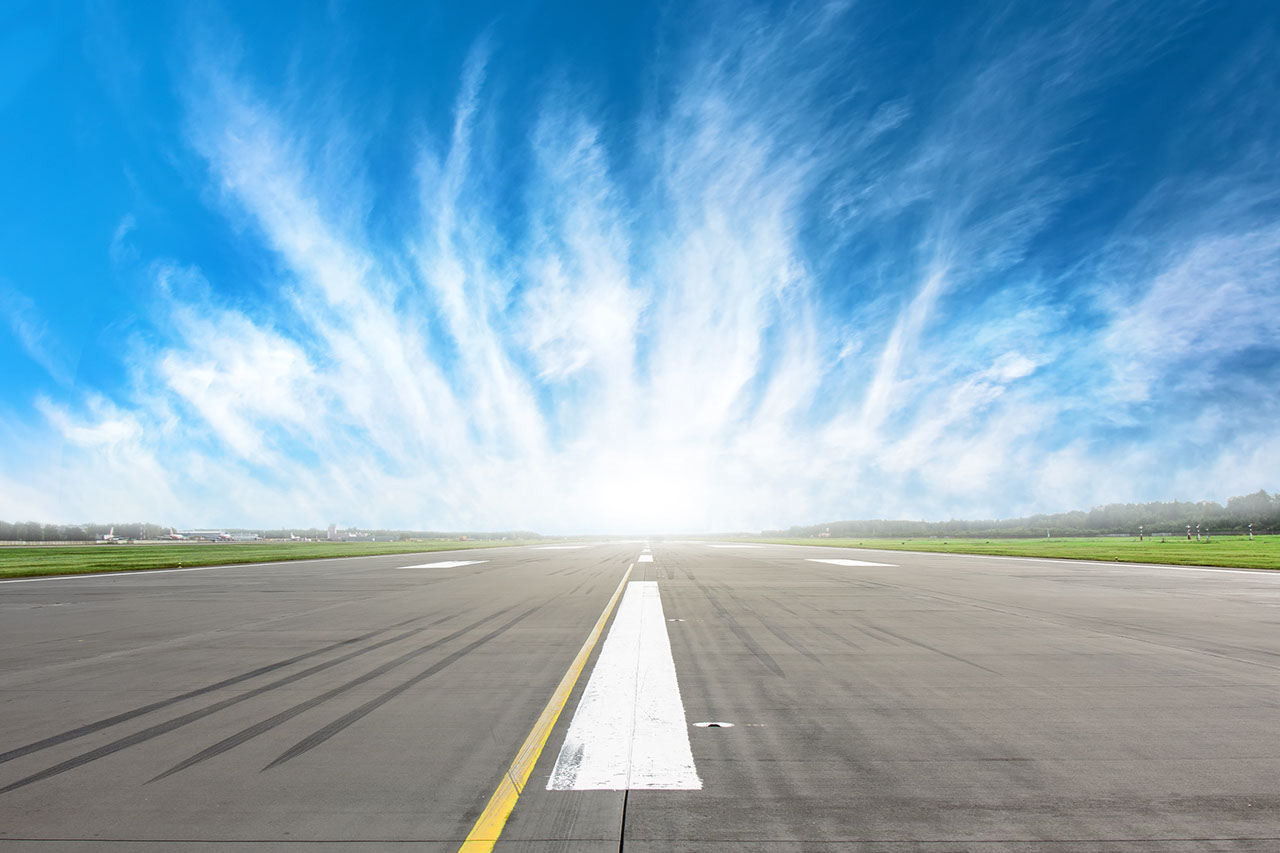 Empty runway strip with markings with beautiful clouds on the horizon