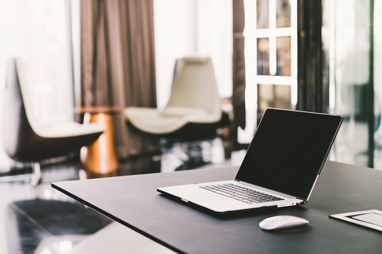 Laptop computer on work table in modern luxury contemporary office. Corporate business, internet information technology, or freelance job working at home concept